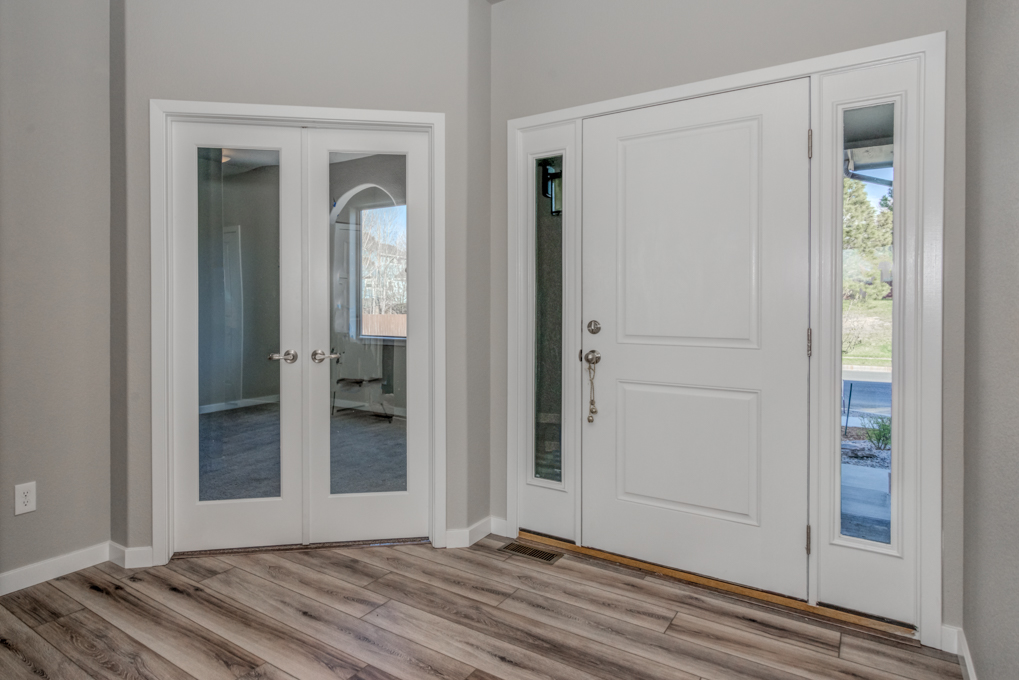 White wooden entrance door with wooden flooring